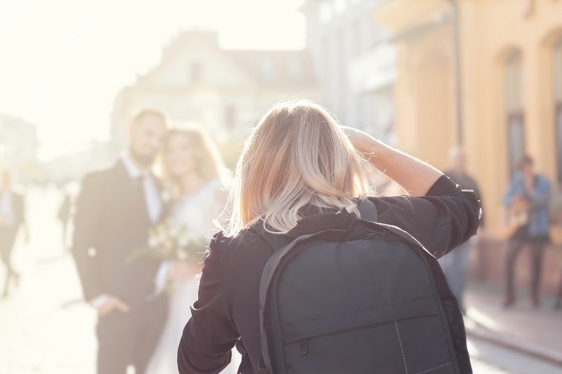 Kobieta fotografująca parę młodą na ulicy miasteczka